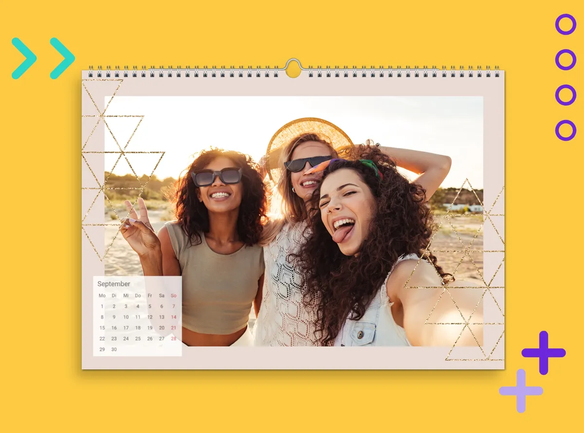 Wandkalender A4 quer mit einem Fotomotiv von drei Freundinnen, die in sommerlicher Kulisse ein Selfie machen. Der Kalender liegt auf einem gelben Hintergrund.